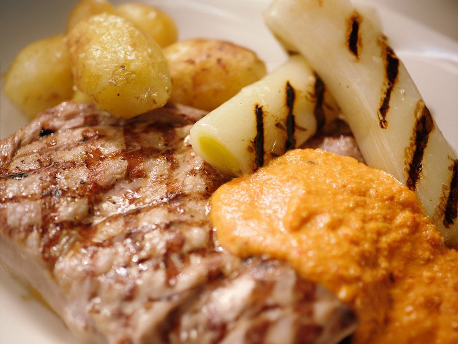 Kalfskotelet romesco met gebraiseerde prei en ratte-aardappelen