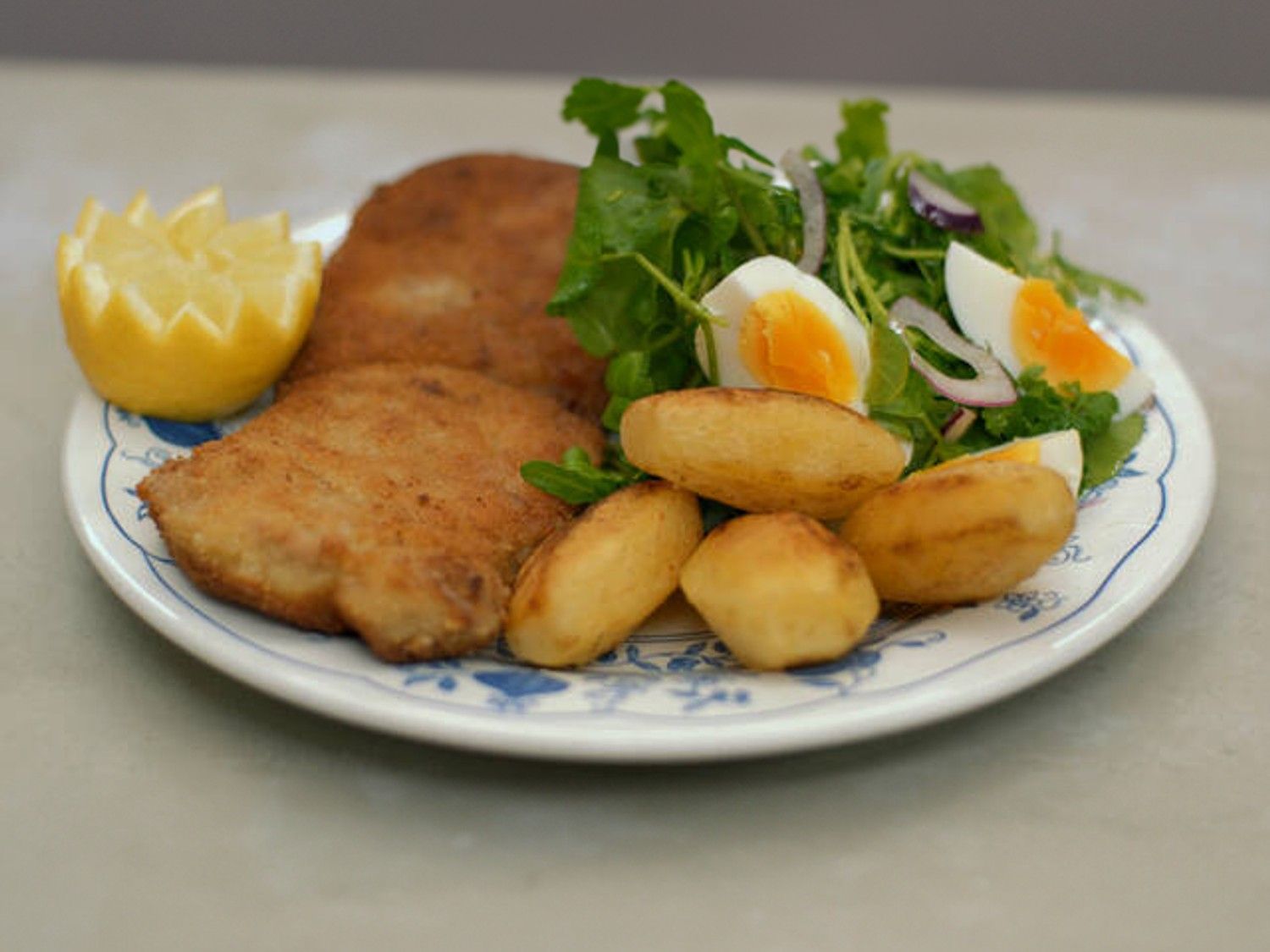Wiener schnitzels met salade en gebakken aardappelen