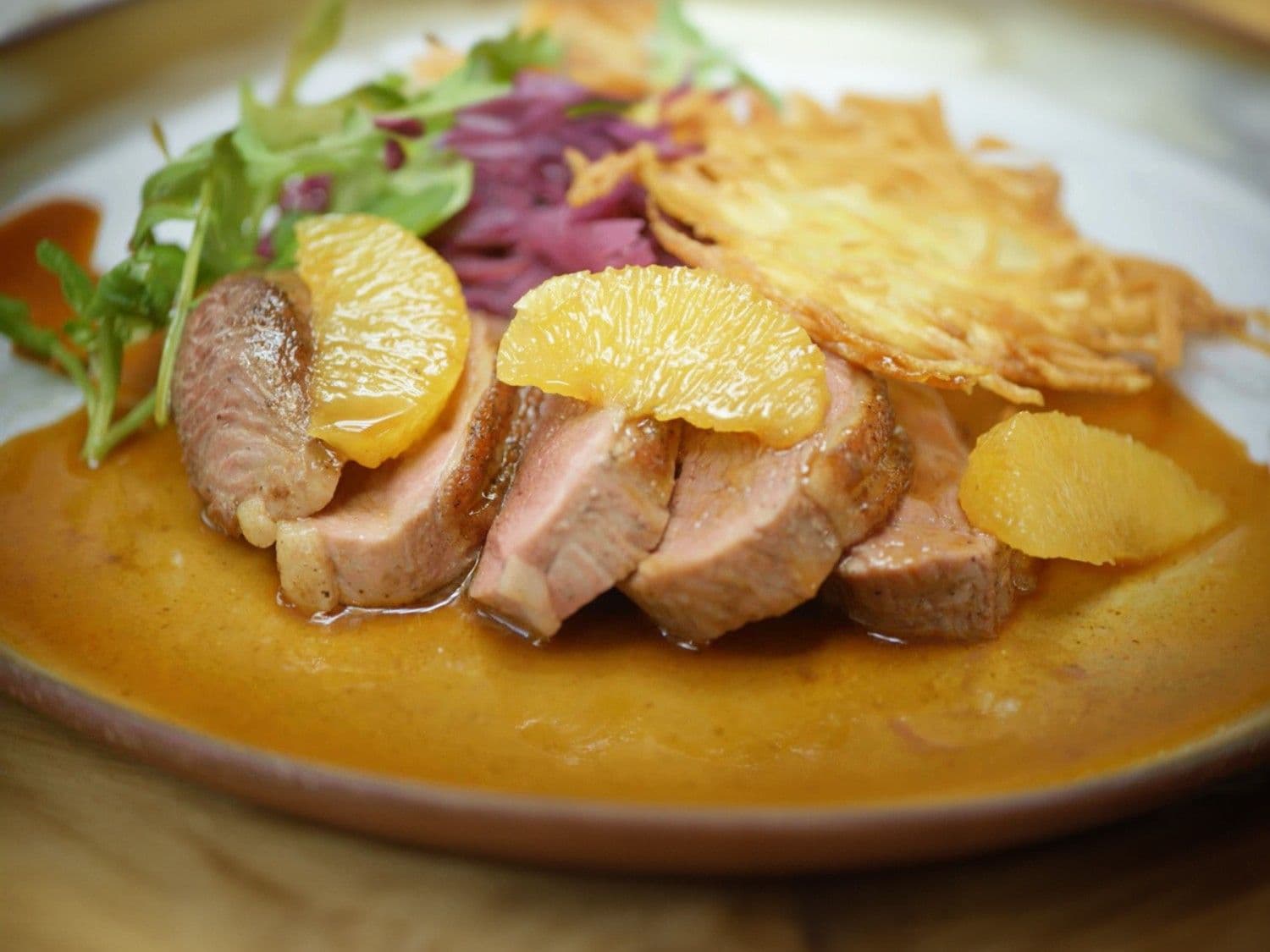 Gebraden eendenborst, sinaasappelsaus, rode kool en aardappelrösti