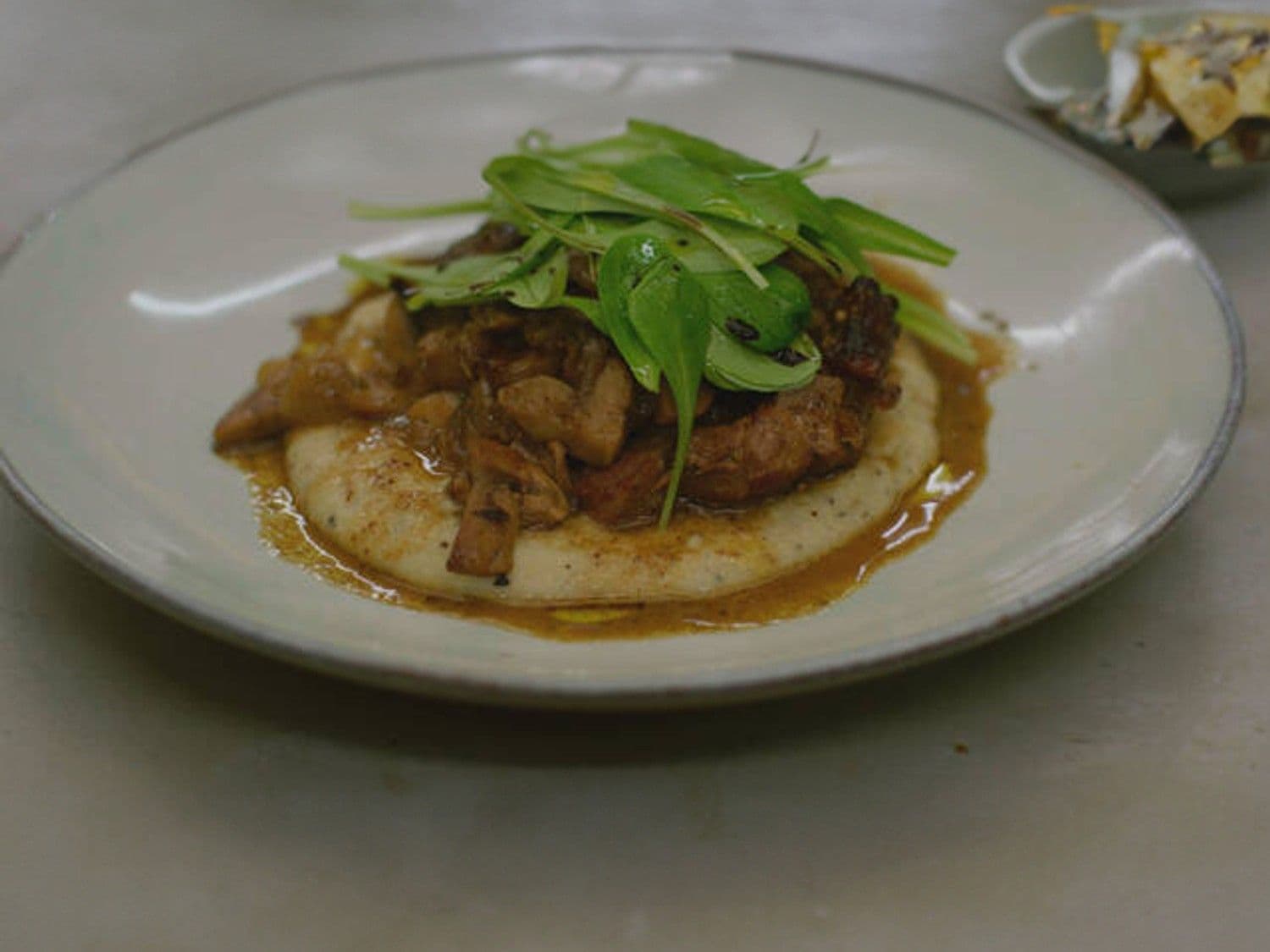 Kalfsschenkel met champignonsaus en truffelpolenta met veldsla