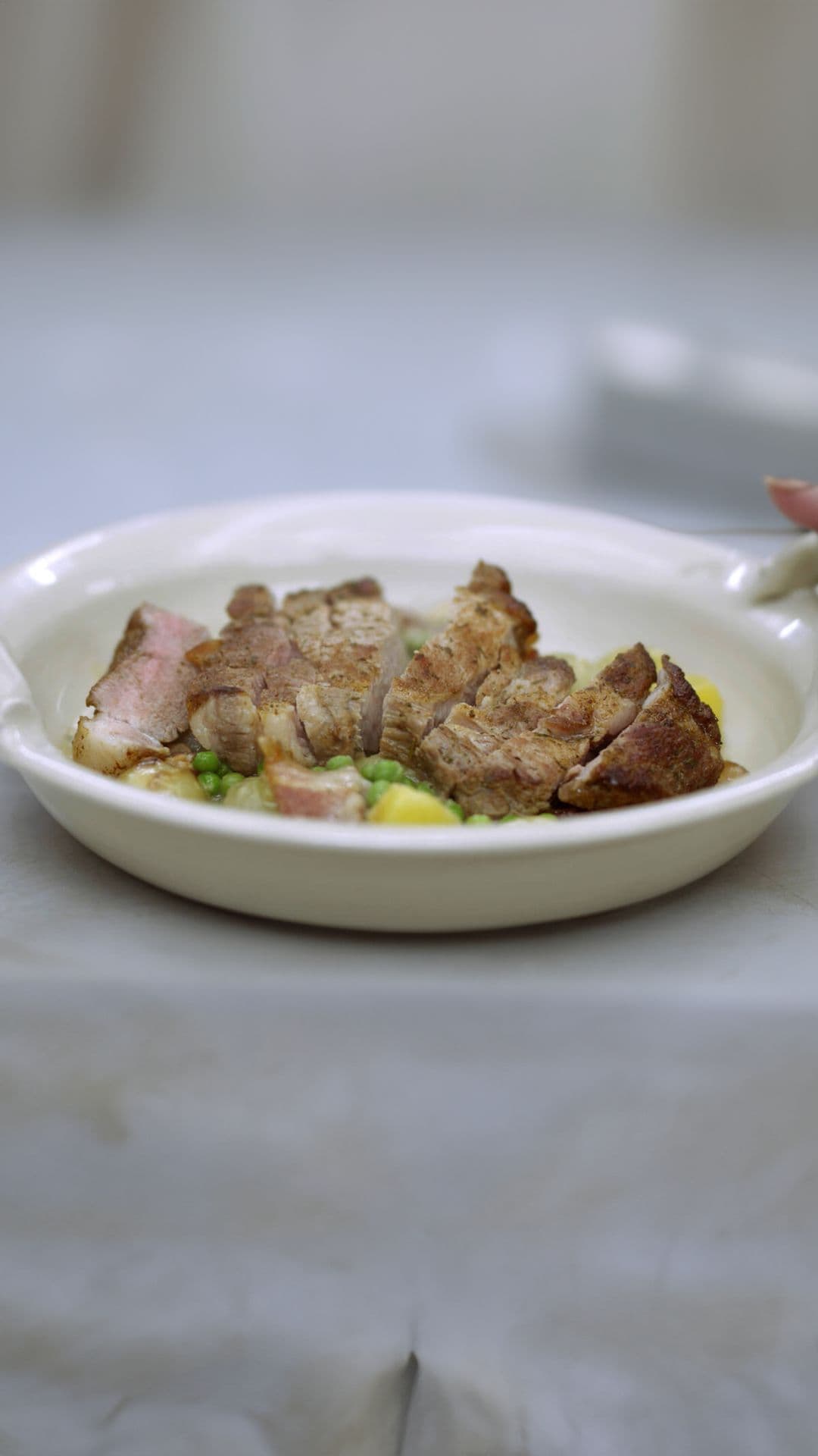 Varkensspiering met fricassee van aardappel, ui, erwten en spek