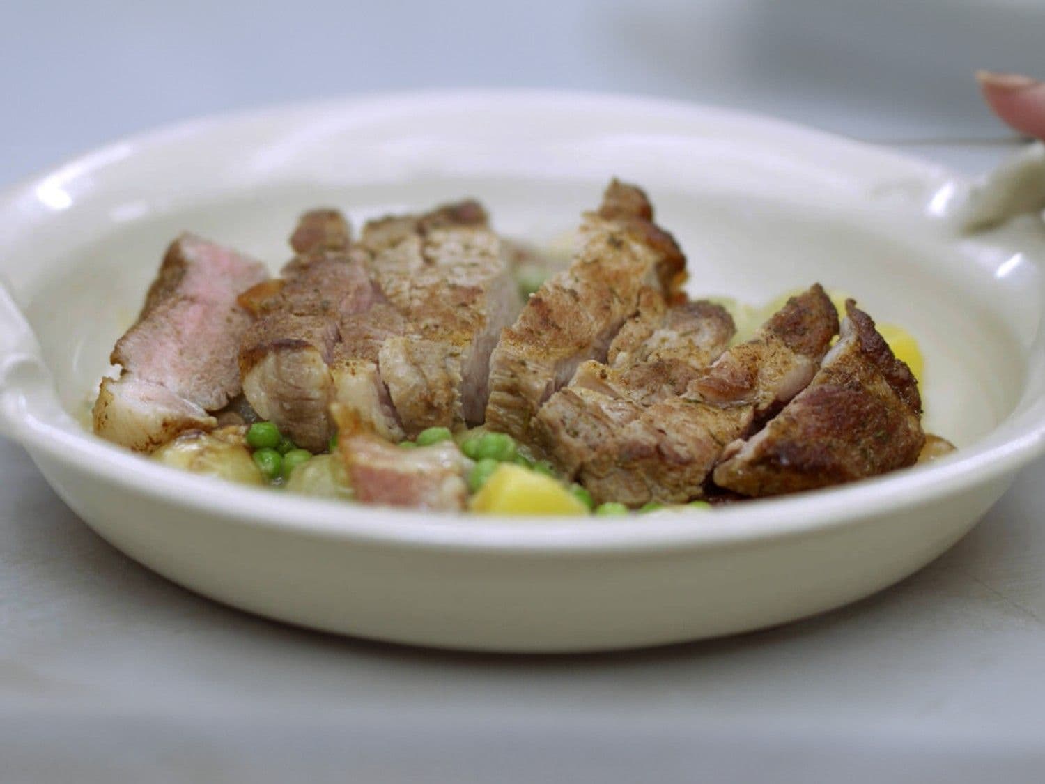 Varkensspiering met fricassee van aardappel, ui, erwten en spek
