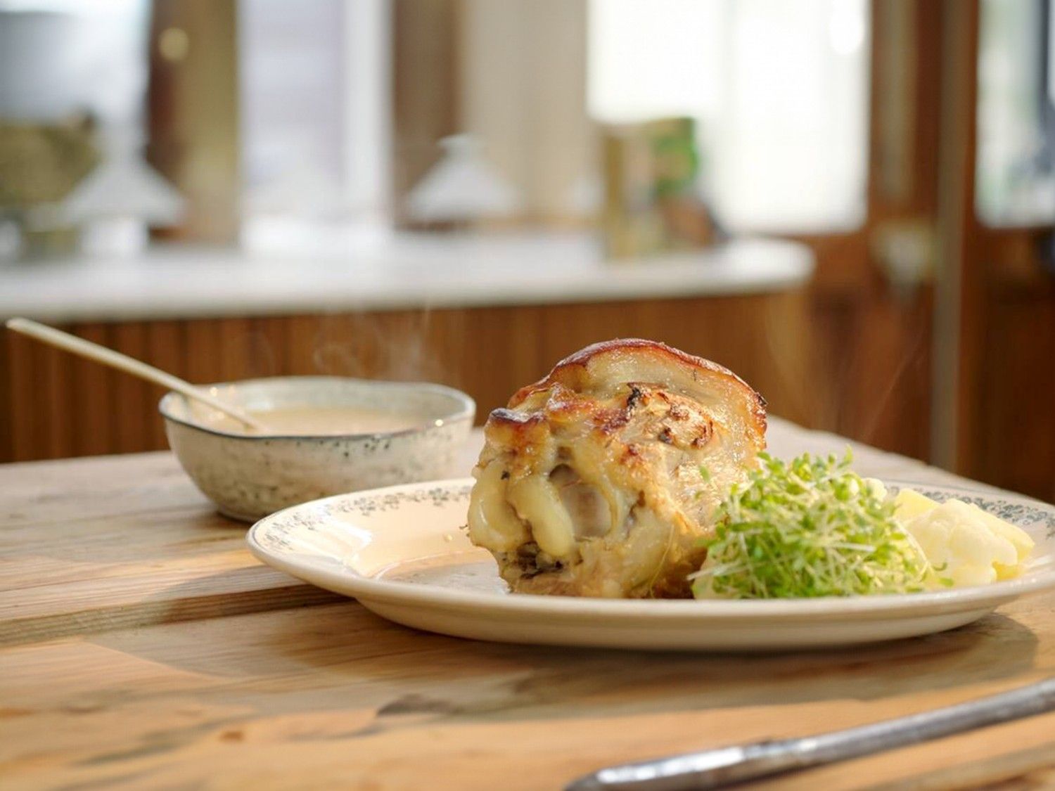 Hammetje in mosterdsaus met bloemkool en aardappelen