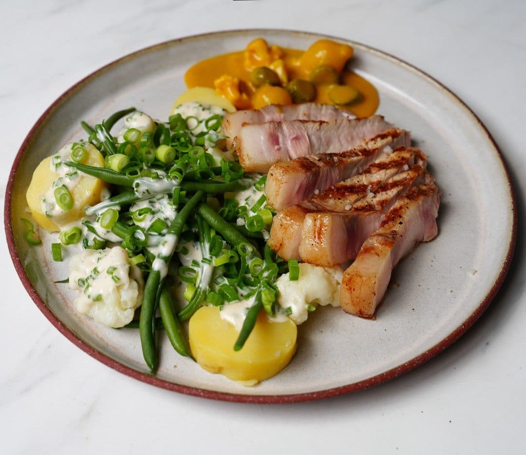 Varkenskotelet met lauwe aardappel en verse pickles