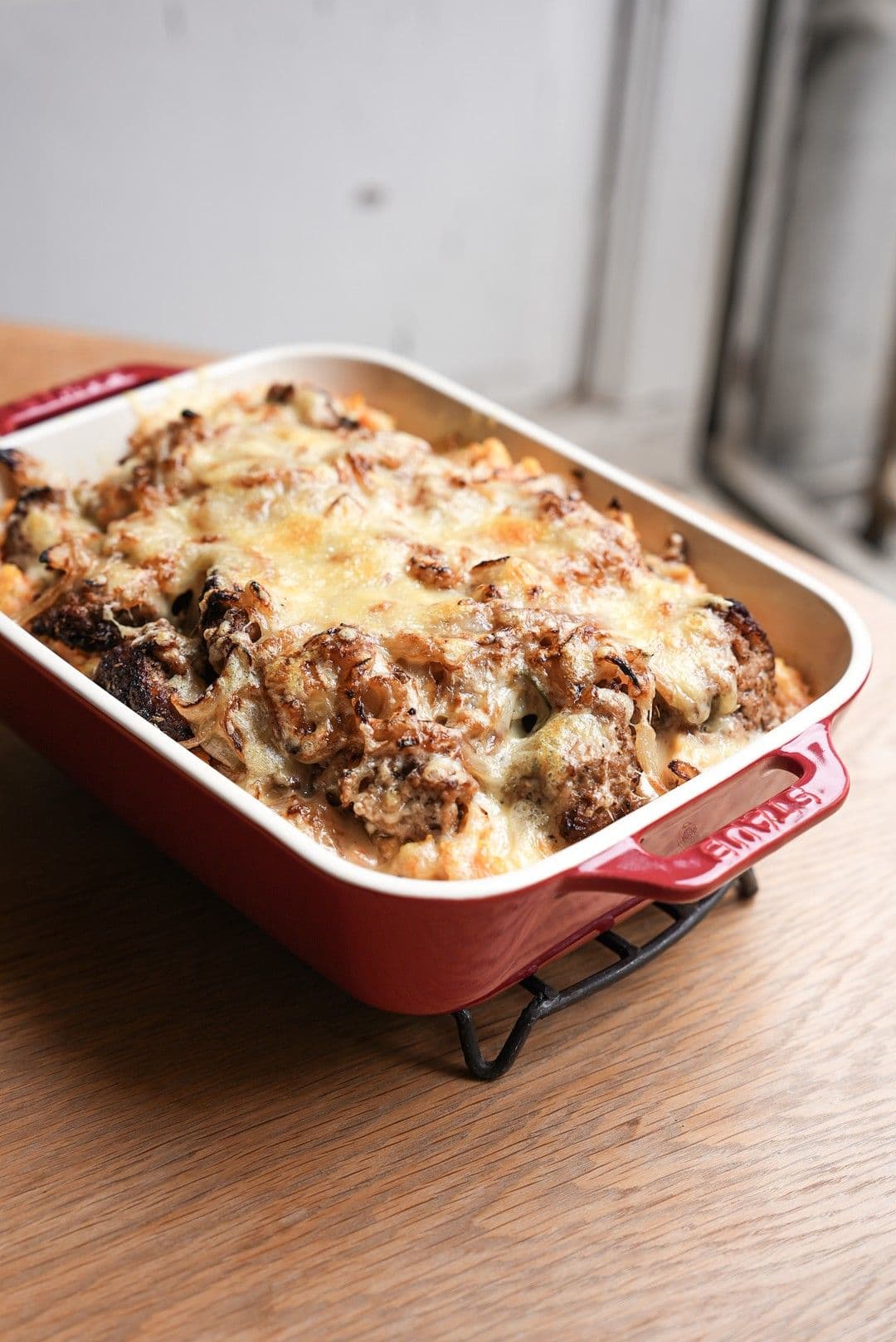 Ovenschotel met wortelpuree, gehakt, gebakken uien en gemalen kaas