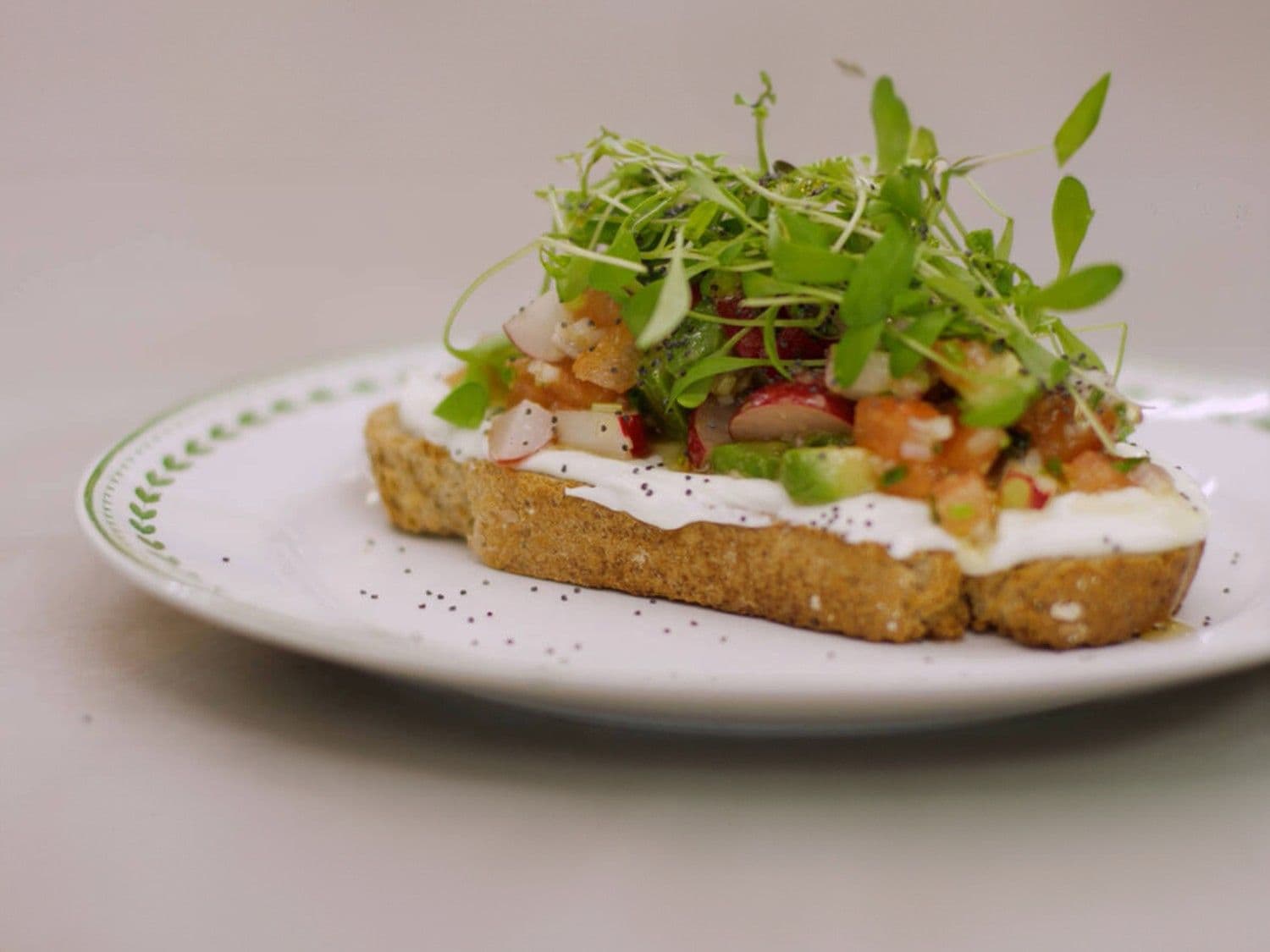 Bruine boterham met plattekaas en salade van radijs