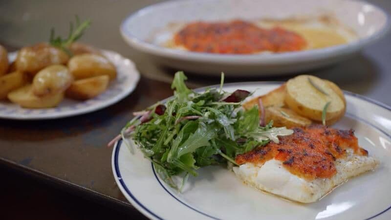 Schelvis met panade van gekonfijte paprika en parmezaan, mesclun en gebakken aardappel