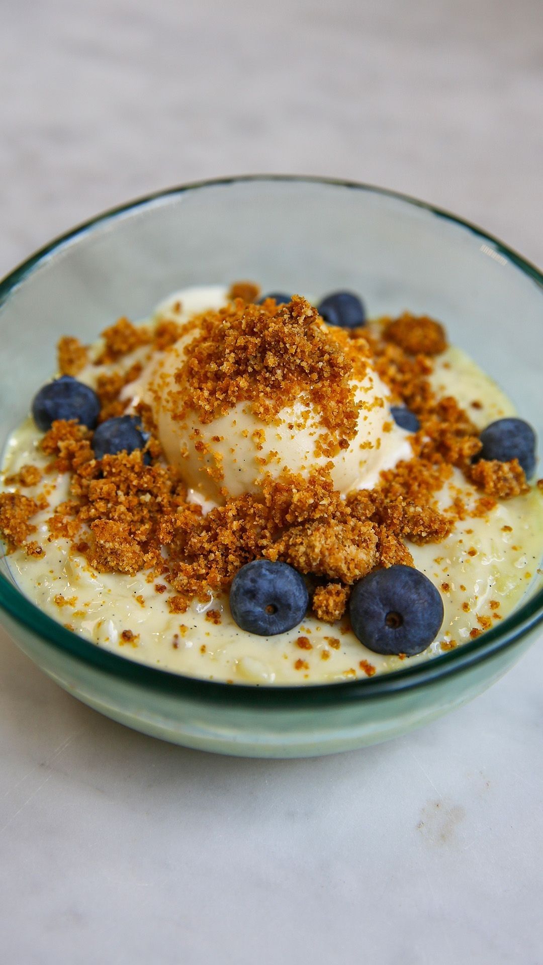 Romige rijstpap met blauwe bessen, hoeve-ijs en crumble