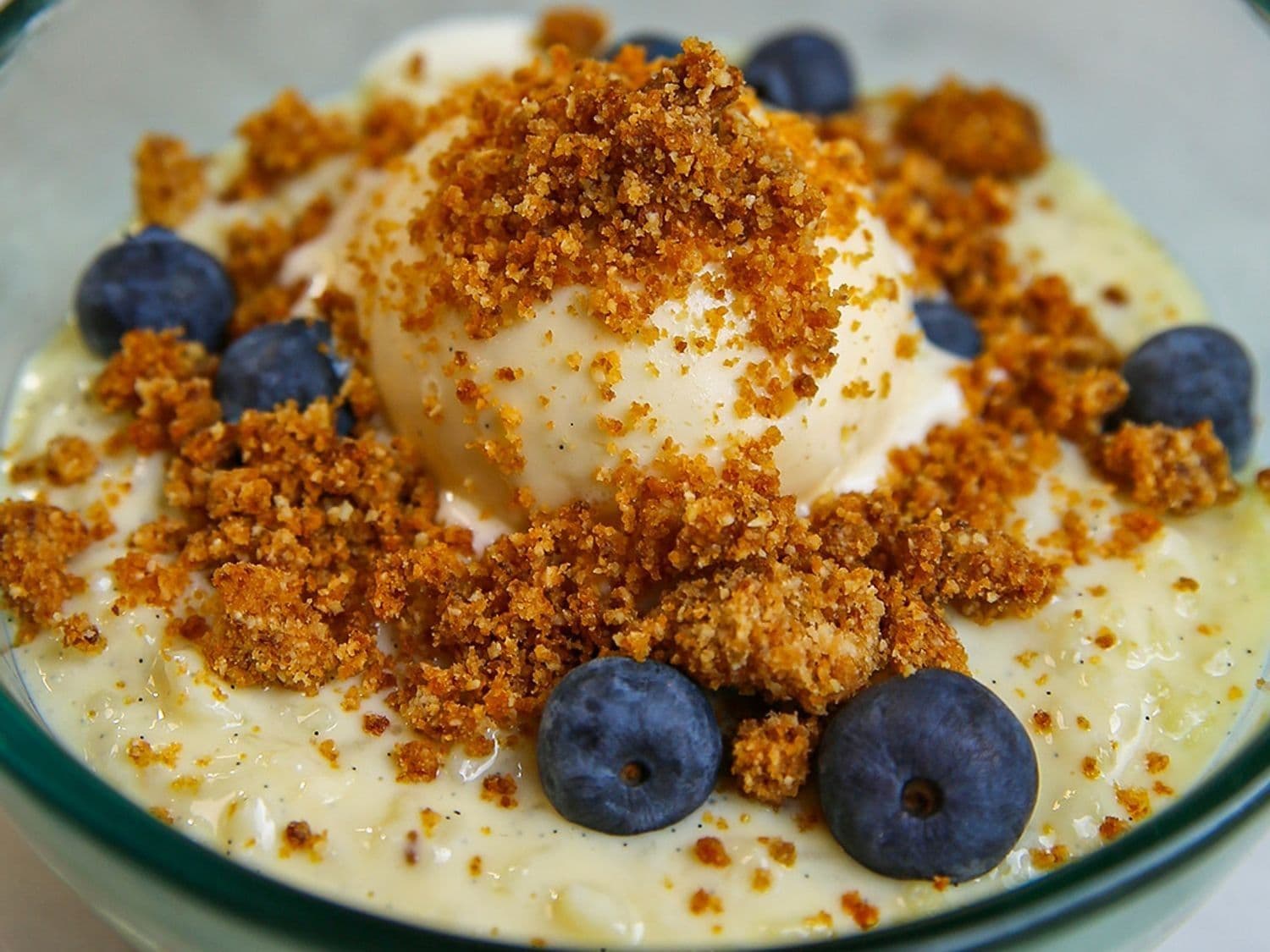 Romige rijstpap met blauwe bessen, hoeve-ijs en crumble