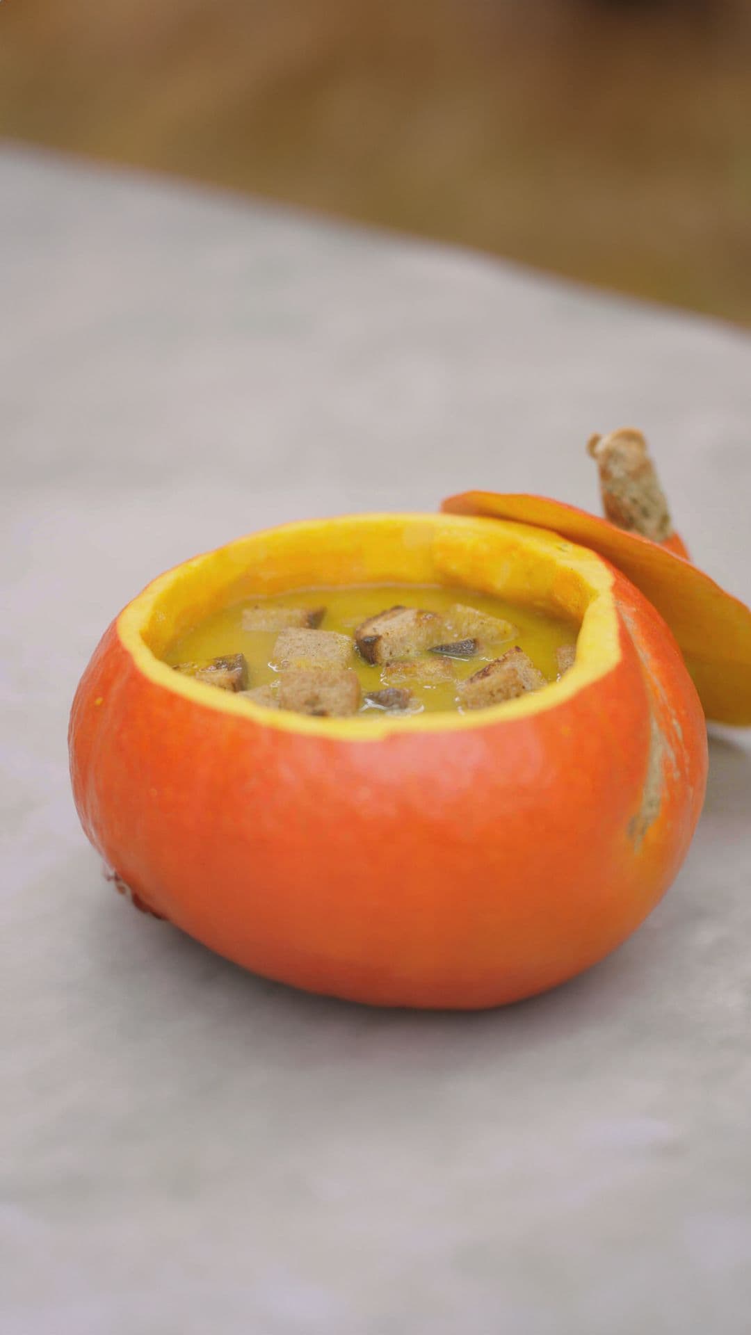 Pompoensoep met kaasblokjes en croutons