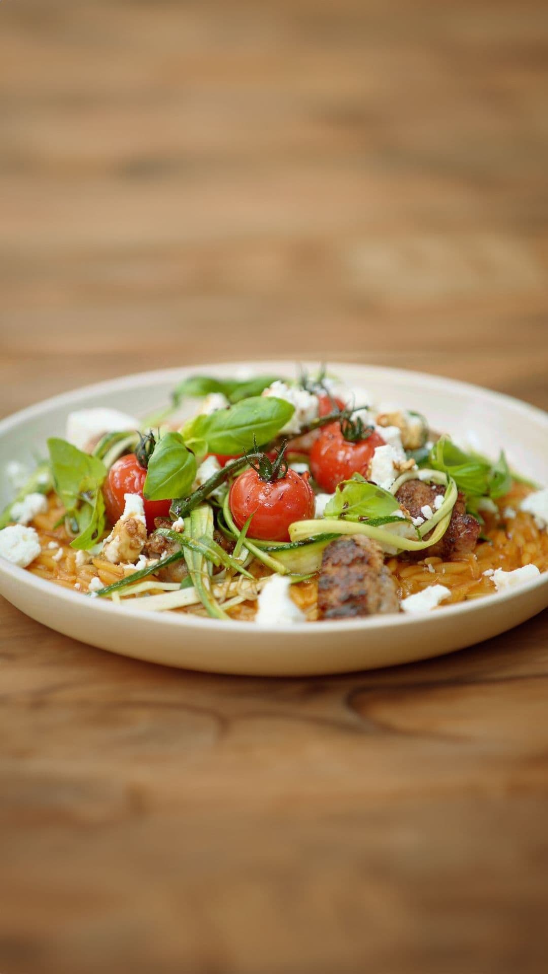 Orzo-risotto met salsiccia, kerstomaten, courgette en feta