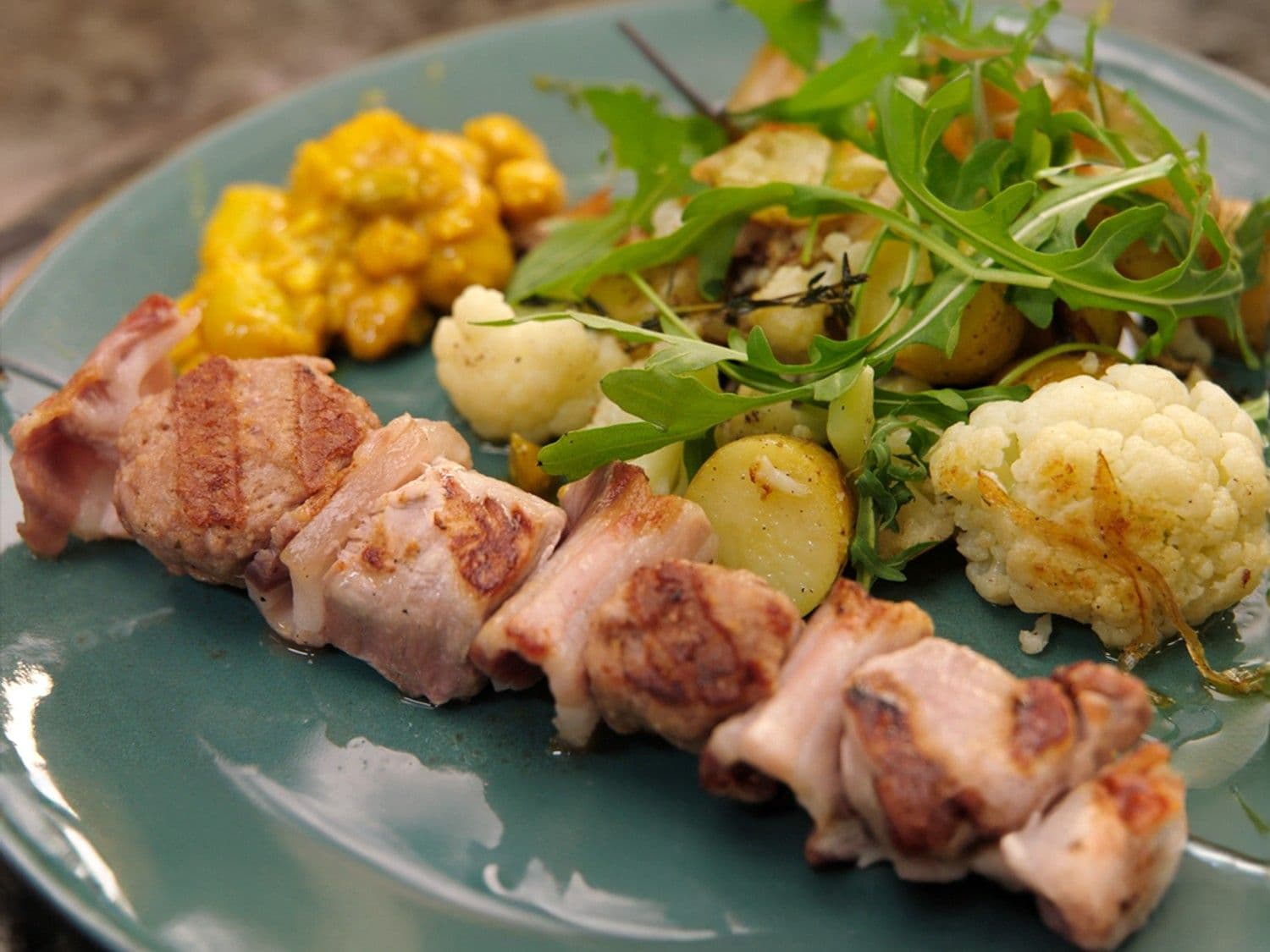 Een pittige varkensbrochette met aardappel en mini-pita’s