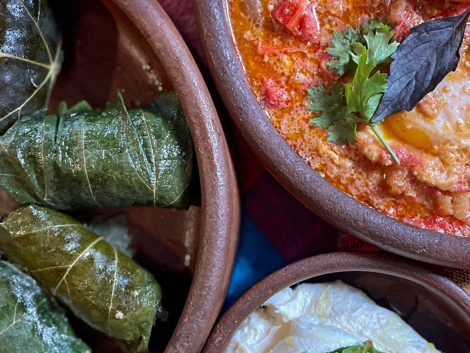 Gepocheerde eieren in tomatensaus en gevulde wijnbladeren