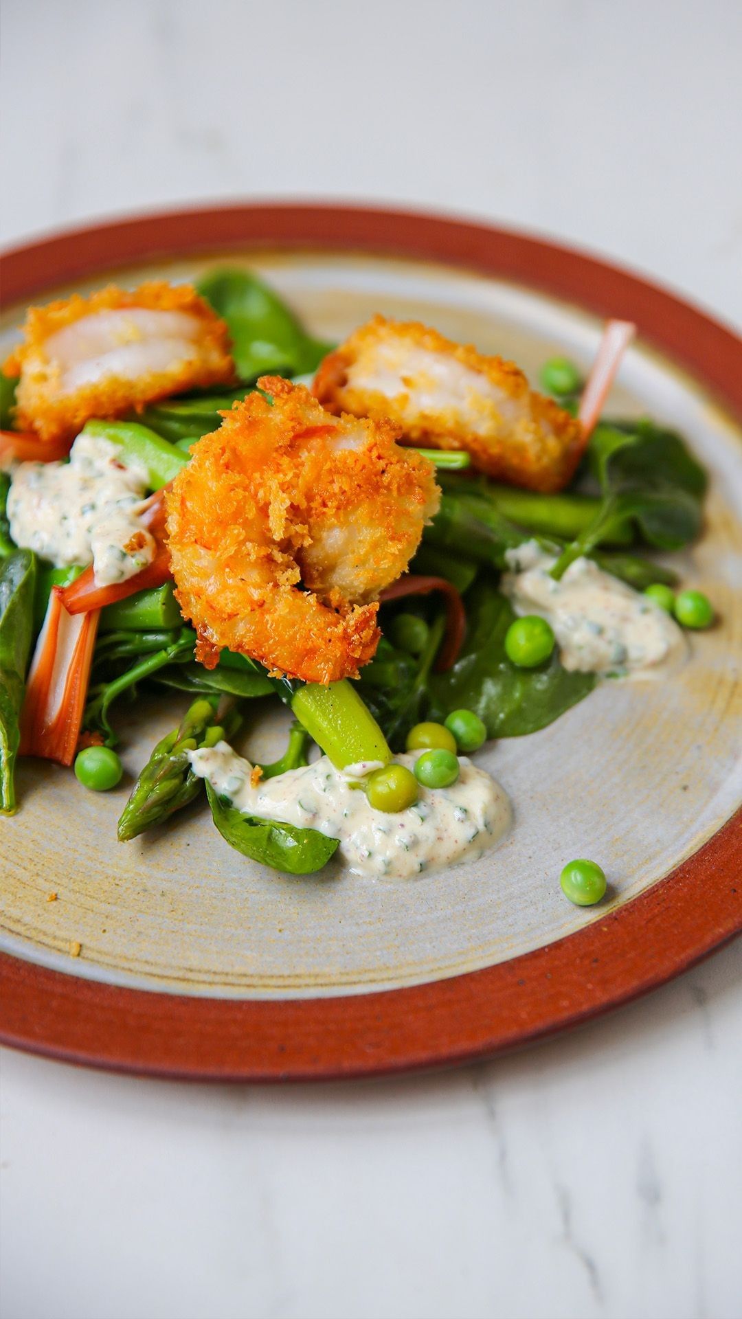 Groene salade met gepaneerde scampi's en dressing met citroen en look