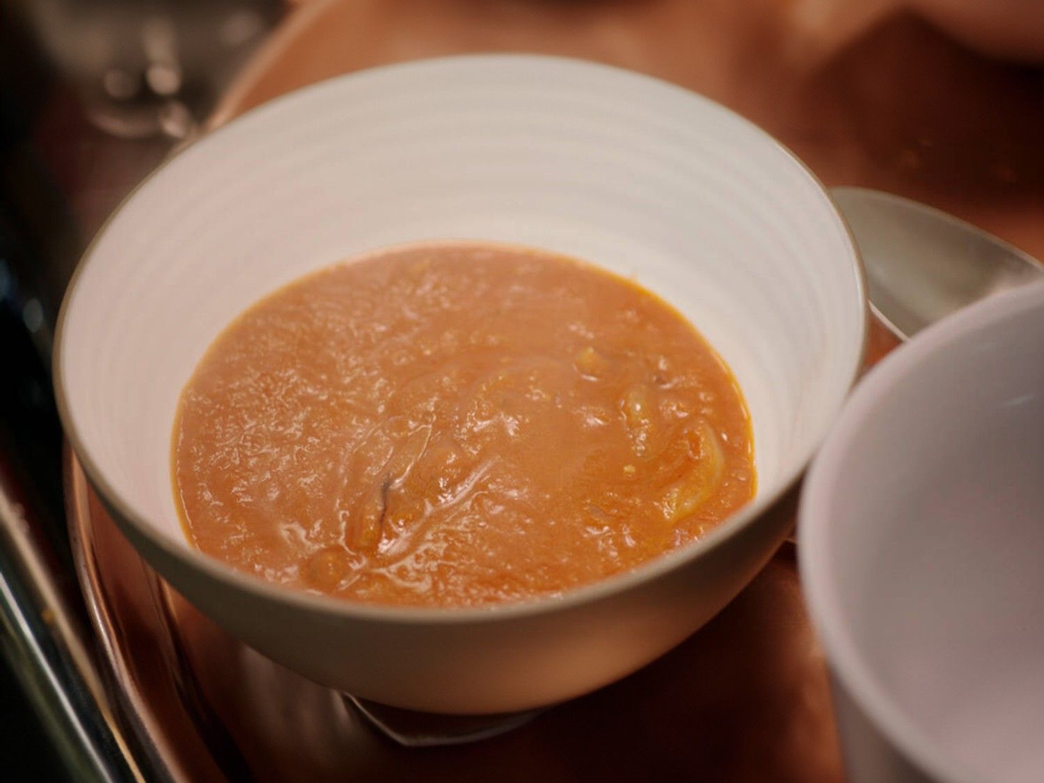 Uien- en tomatensoep met gebakken ui en spekjes