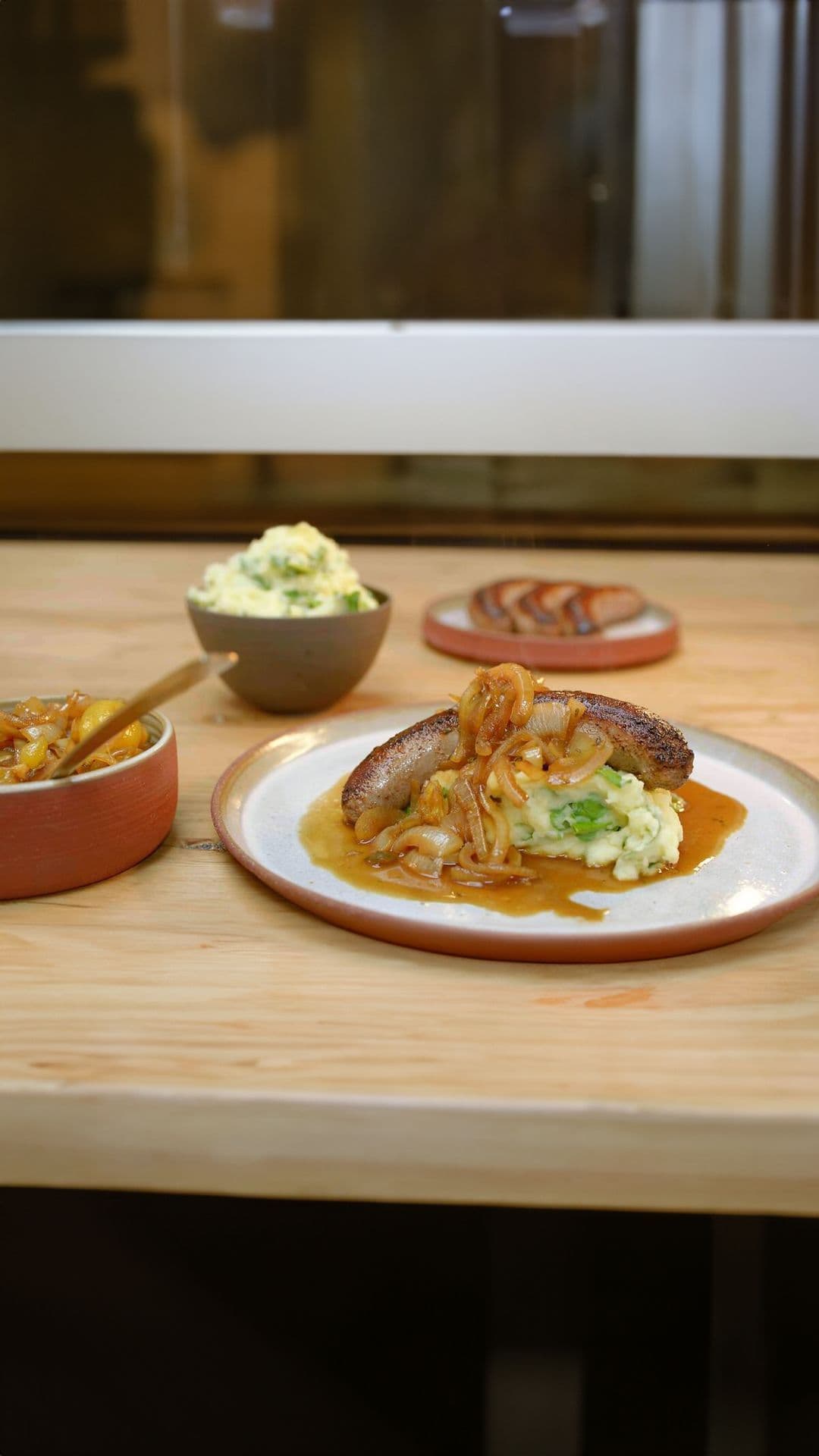 Braadworst met uiensaus en waterkerspuree