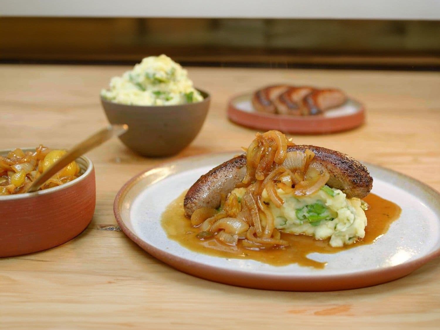 Braadworst met uiensaus en waterkerspuree