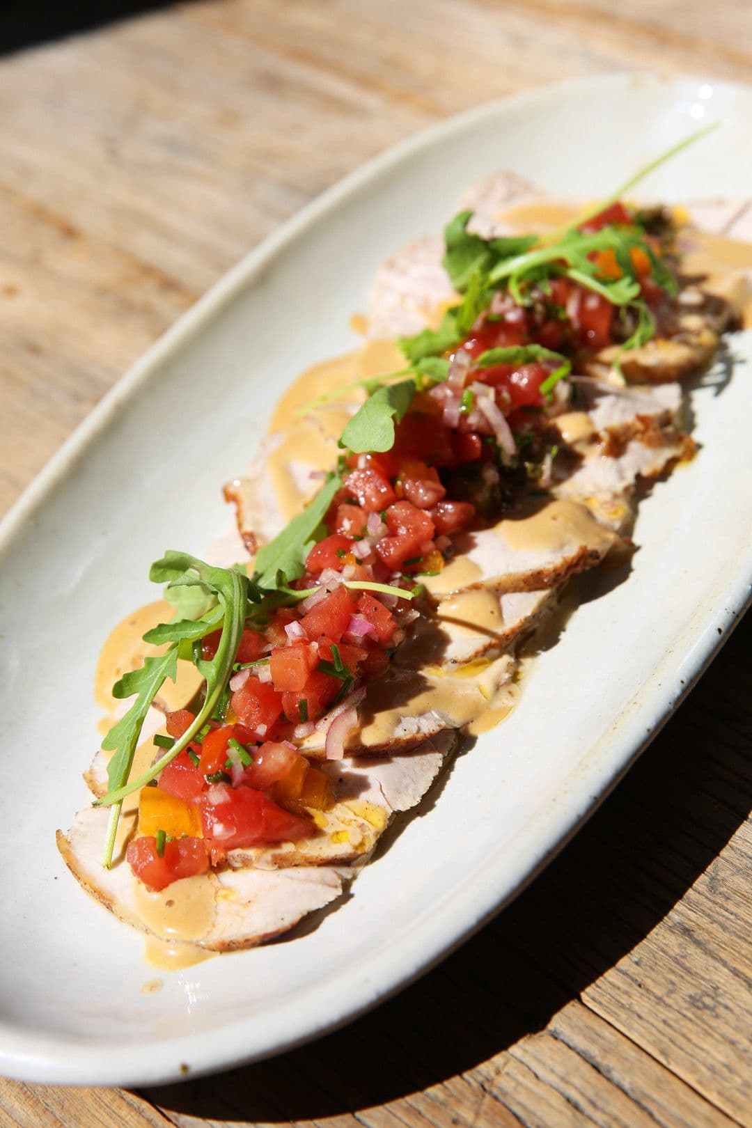 Carpaccio van varkensgebraad met ansjoviscrème en tomatensalsa