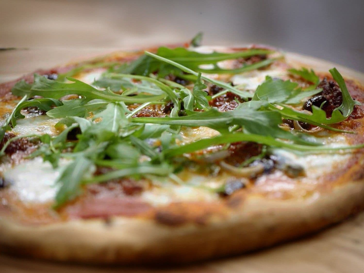 Nduja pizza met mozzarella, olijven en kappertjes 