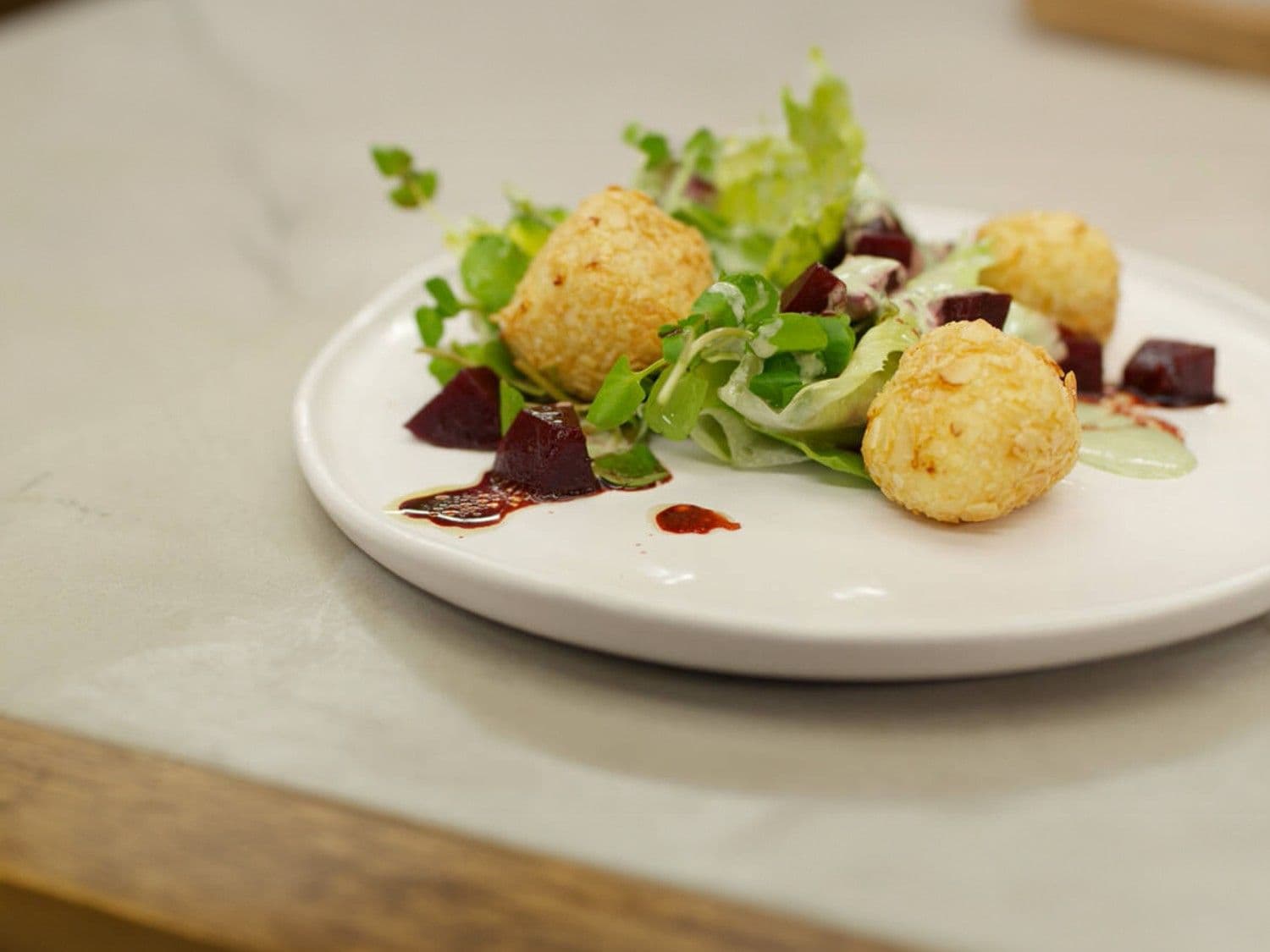 Krokante balletjes van geitenkaas met biet en kruidendressing