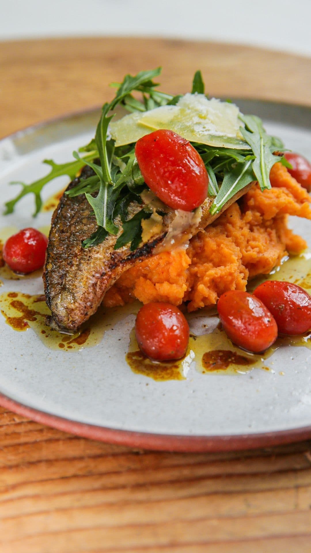 Gebakken dorade met rode pestopuree, rucola en gemarineerde kerstomaten