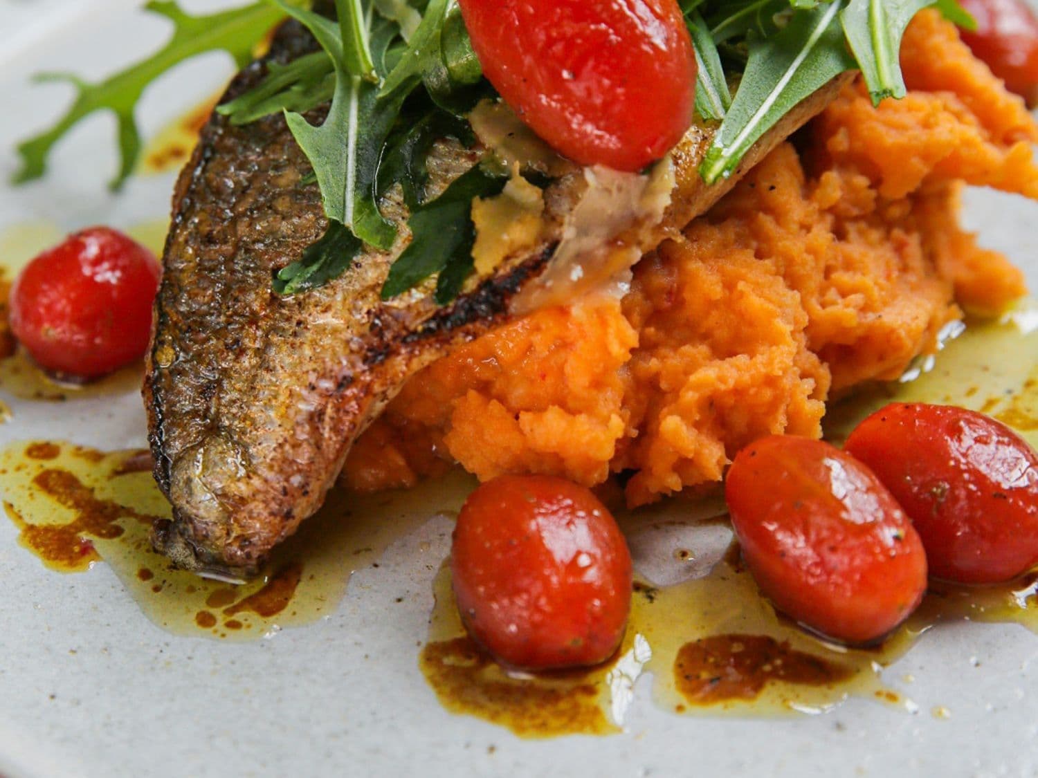 Gebakken dorade met rode pestopuree, rucola en gemarineerde kerstomaten