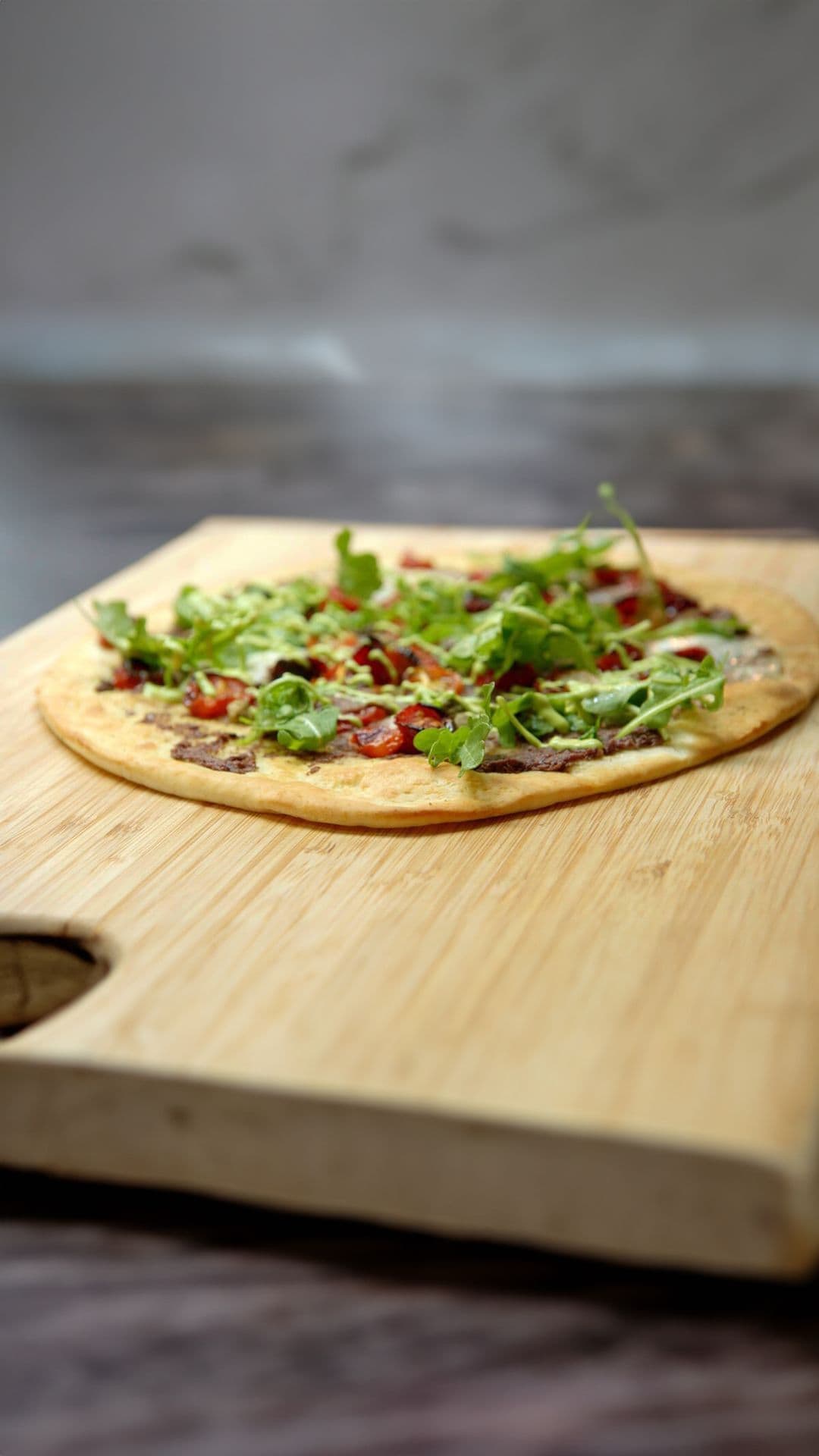 Pizza met tapenade van olijven, gekonfijte tomaten en basilicum aïoli