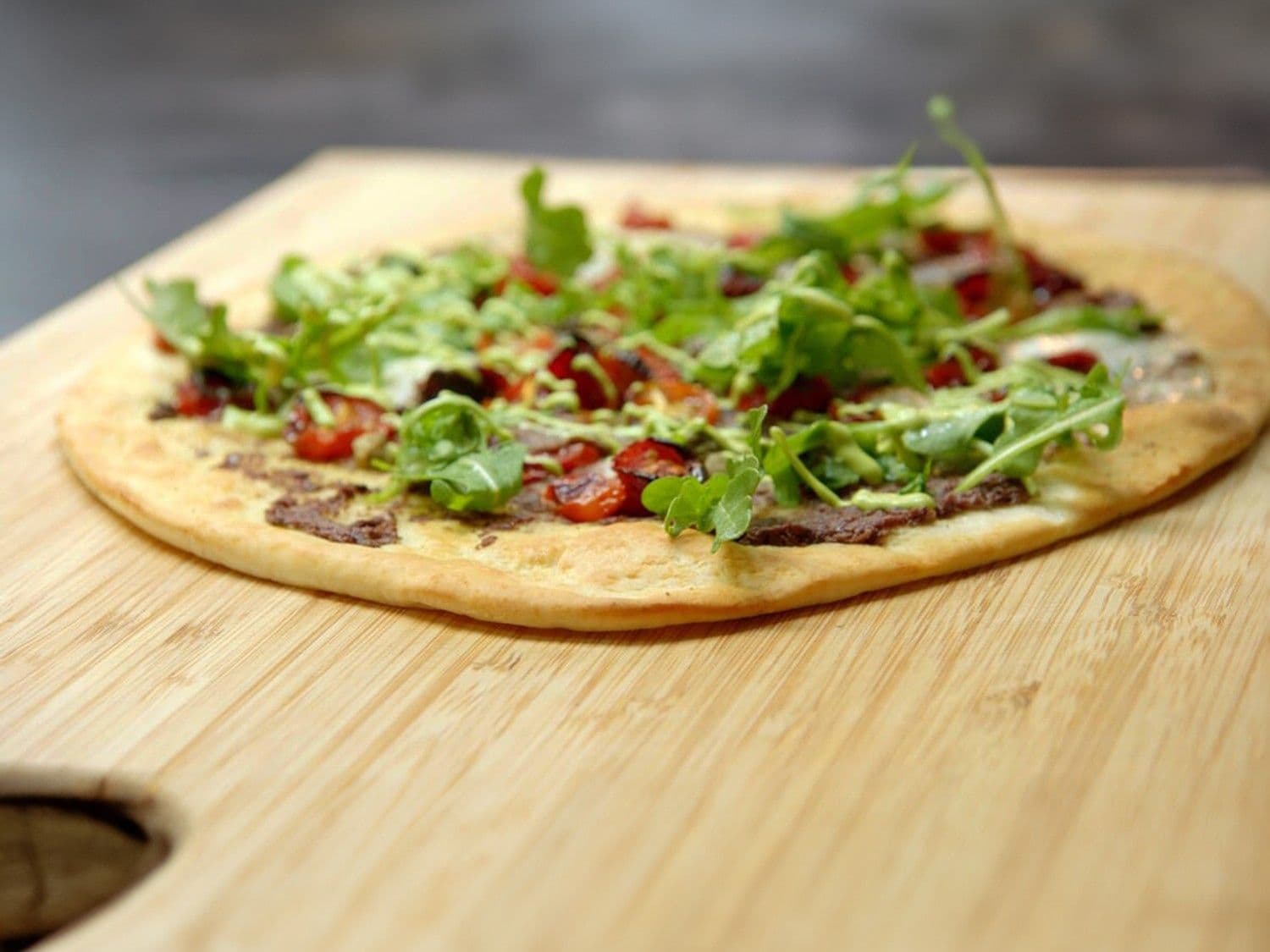 Pizza met tapenade van olijven, gekonfijte tomaten en basilicum aïoli