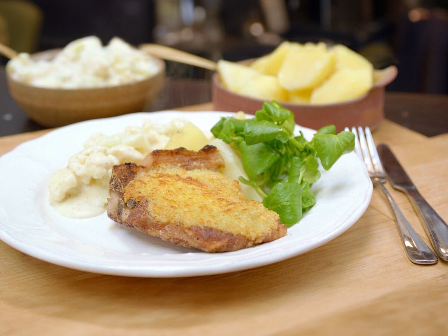 Kotelet met bloemkool in witte saus en gekookte aardappelen