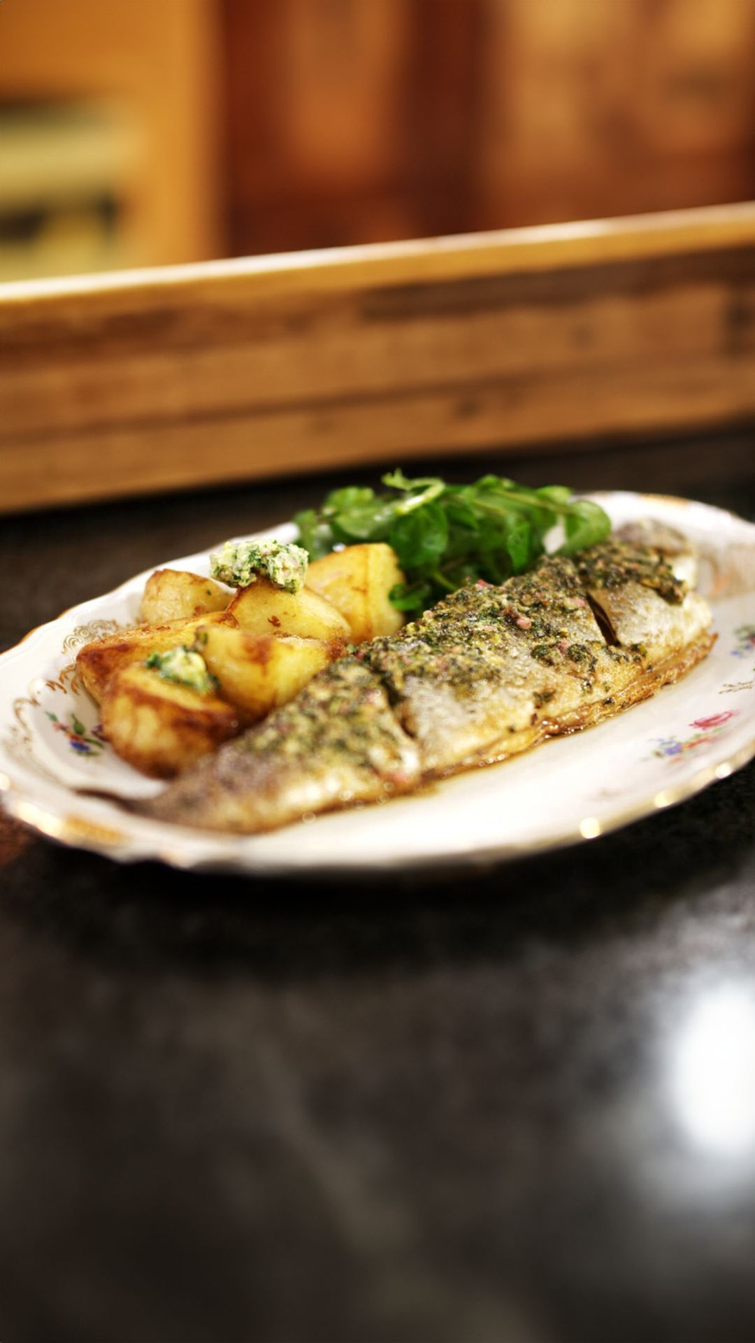 Forel met kruidenboter, gebakken aardappelen en waterkers