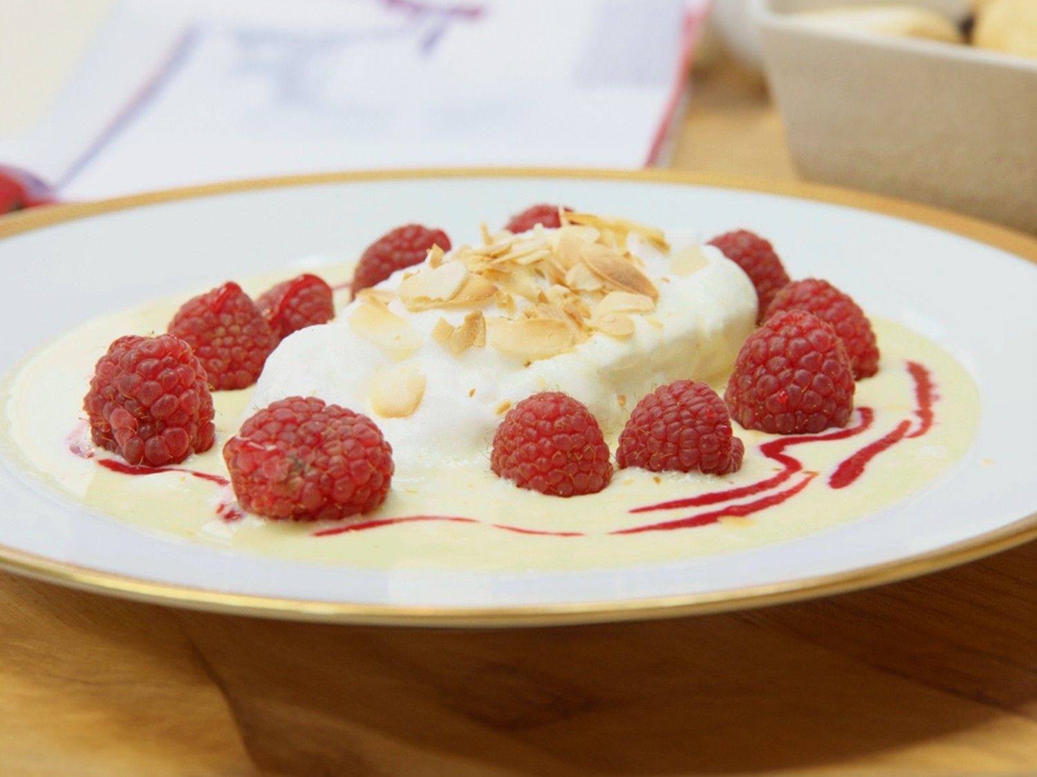 Floating Islands zet citrus-vanillesaus, frambozen in amandelschilfers
