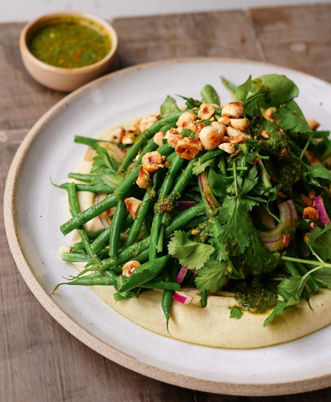 Hummus van witte bonen, salade met groene boontjes, hazelnoten en chermoula