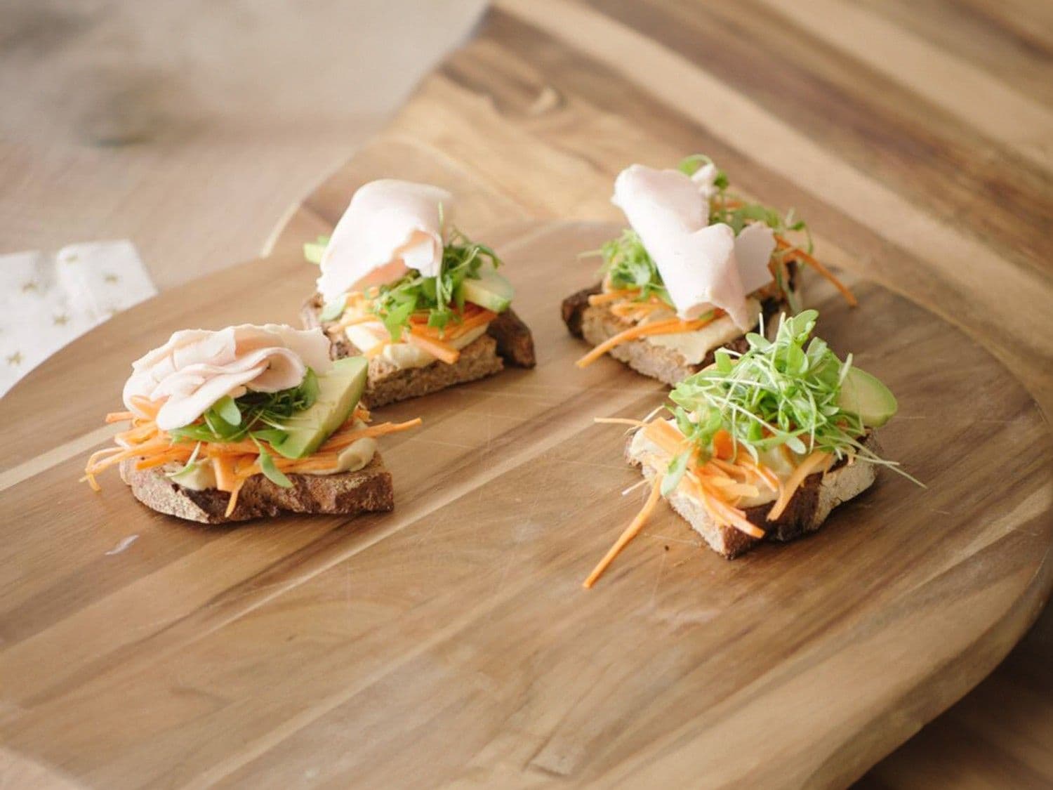 Havermoutmuffins met kokos en braambessen, piña colada smoothie en een toast met hummus en kippenwit