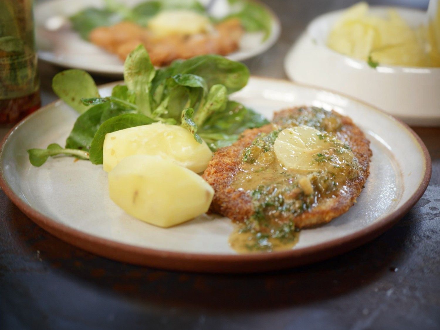 Uierschnitzel piccata met gekookte aardappel en veldsla