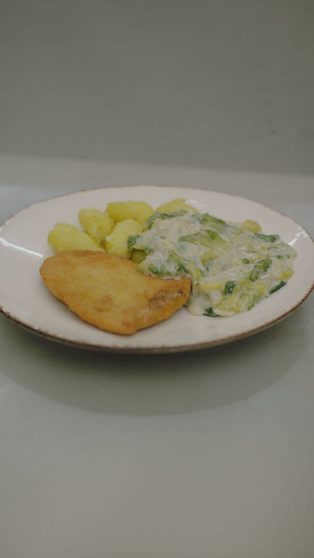 Krokante kalkoenlapjes met gerookte ham en andijvie in kaassaus