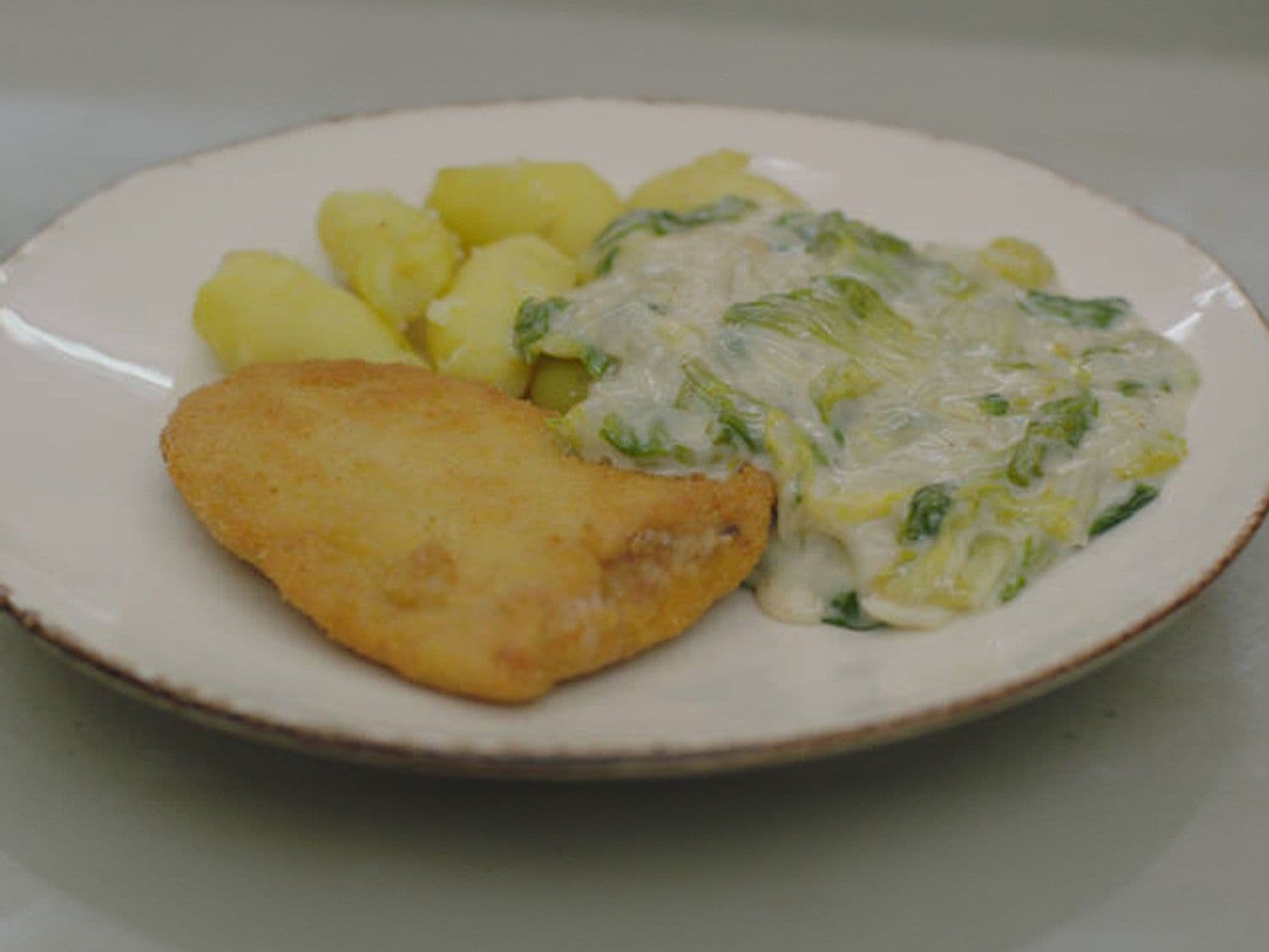 Krokante kalkoenlapjes met gerookte ham en andijvie in kaassaus