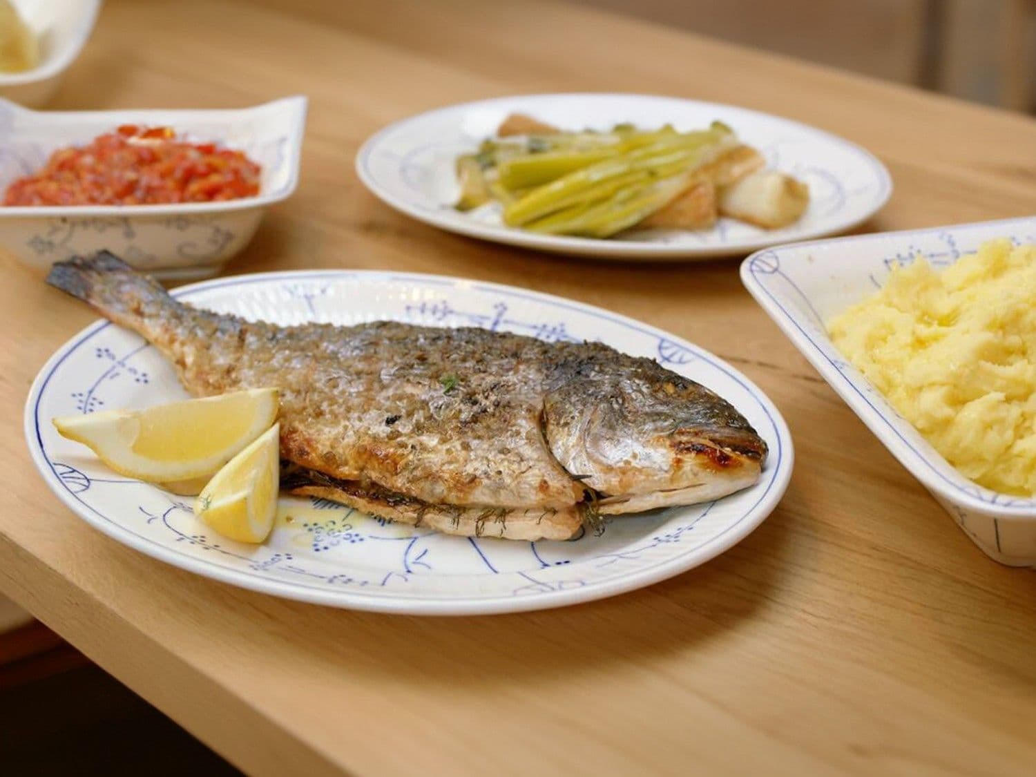 Gegrilde dorade met tuinkruiden en citroen, geroosterde prei en paprikaharissa