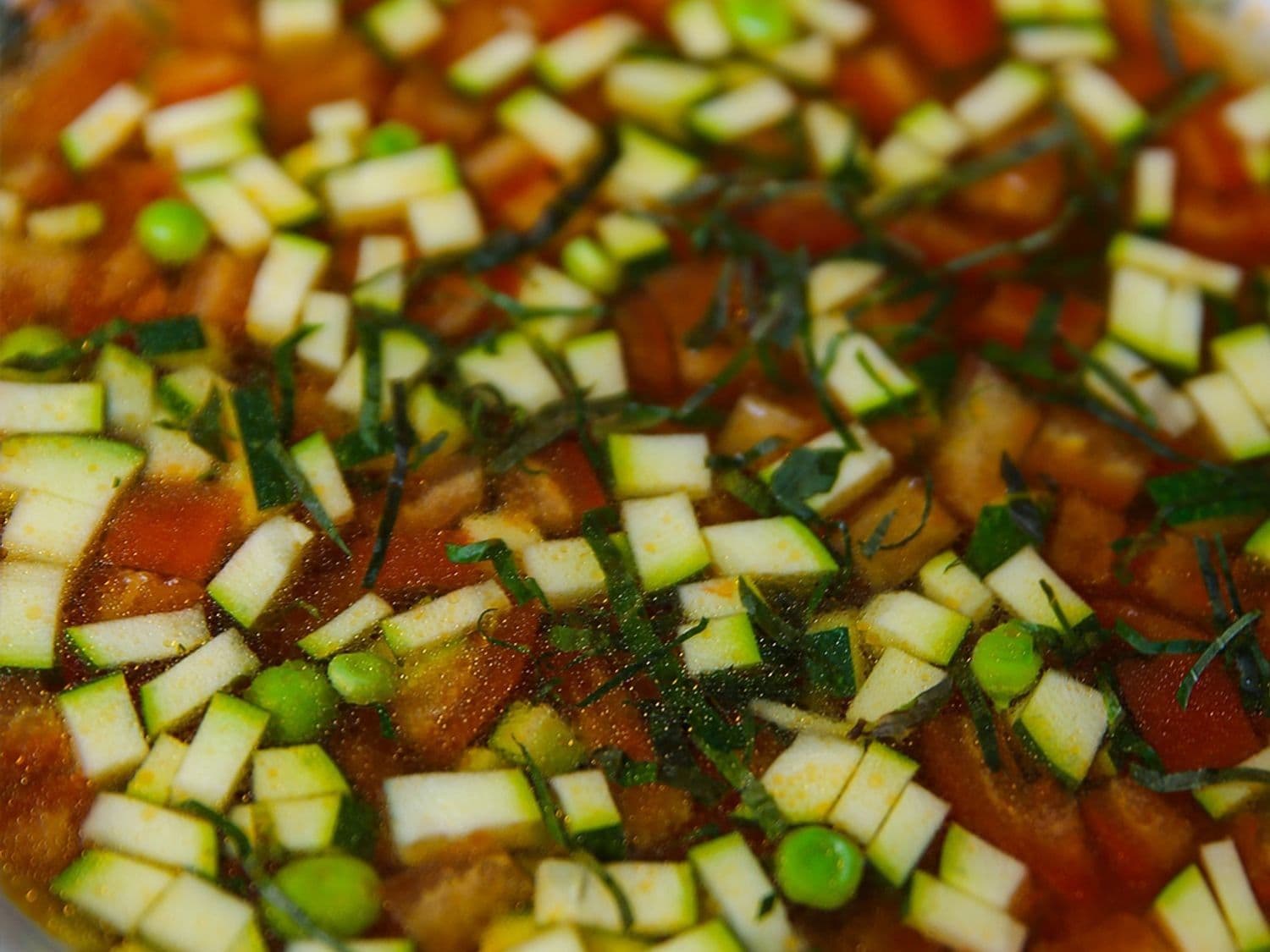Tomatenconsommé met basilicum en erwtjes