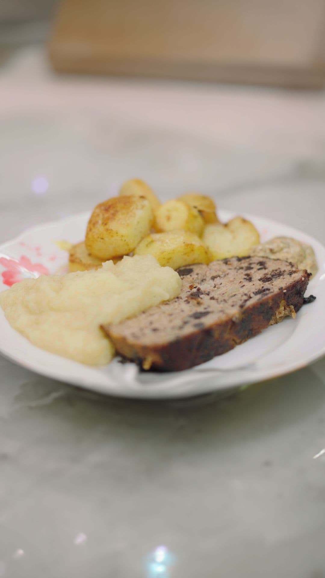 Gehaktbrood met zwarte pens, appelmoes en gebakken aardappelen