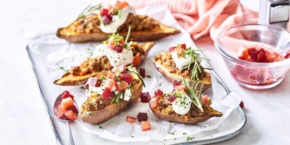 Gepofte zoete aardappel gevuld met gehakt, rode biet en tomaten