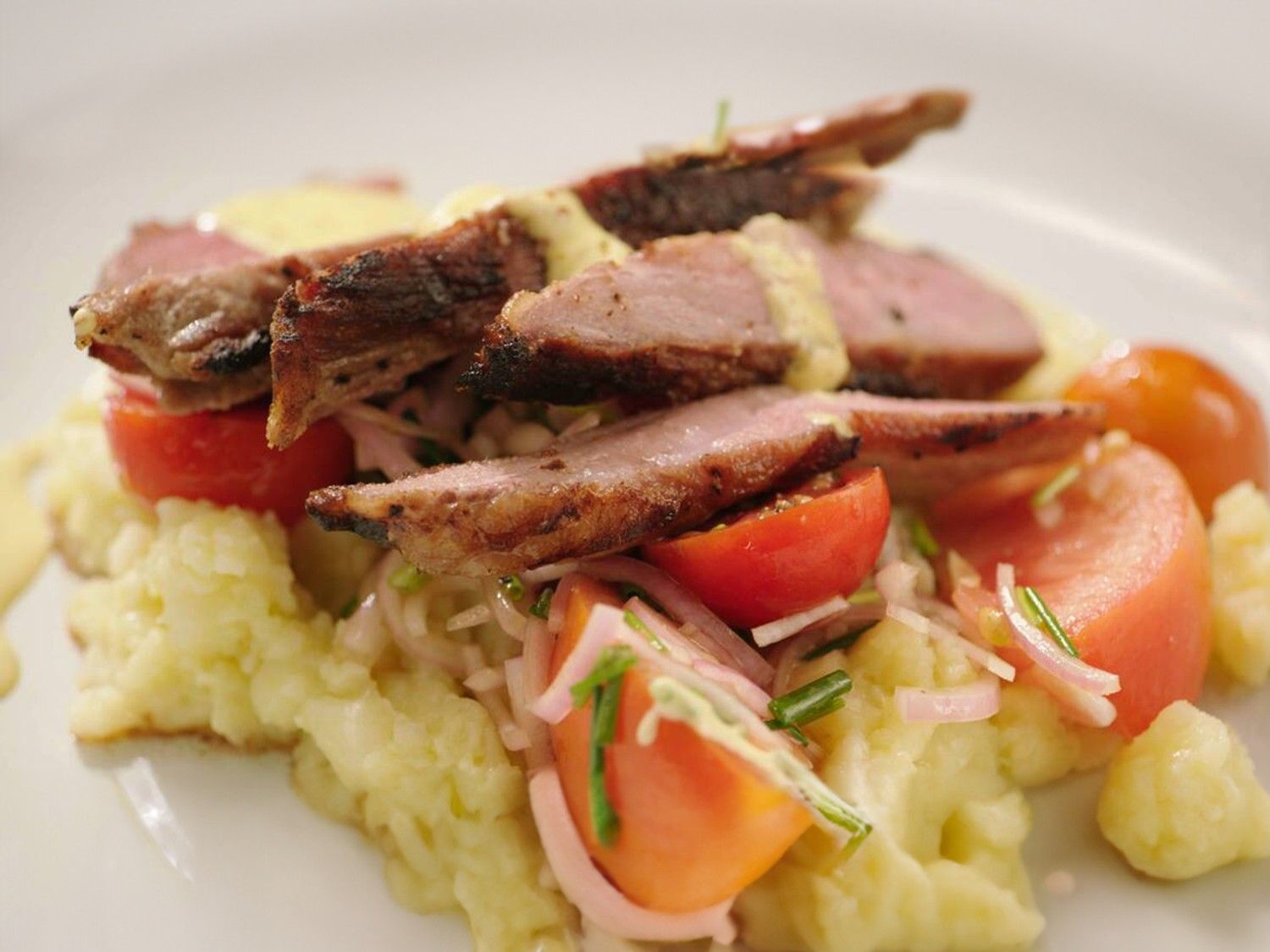 Gegrilde secreto met geplette aardappel, tomatensla en aioli