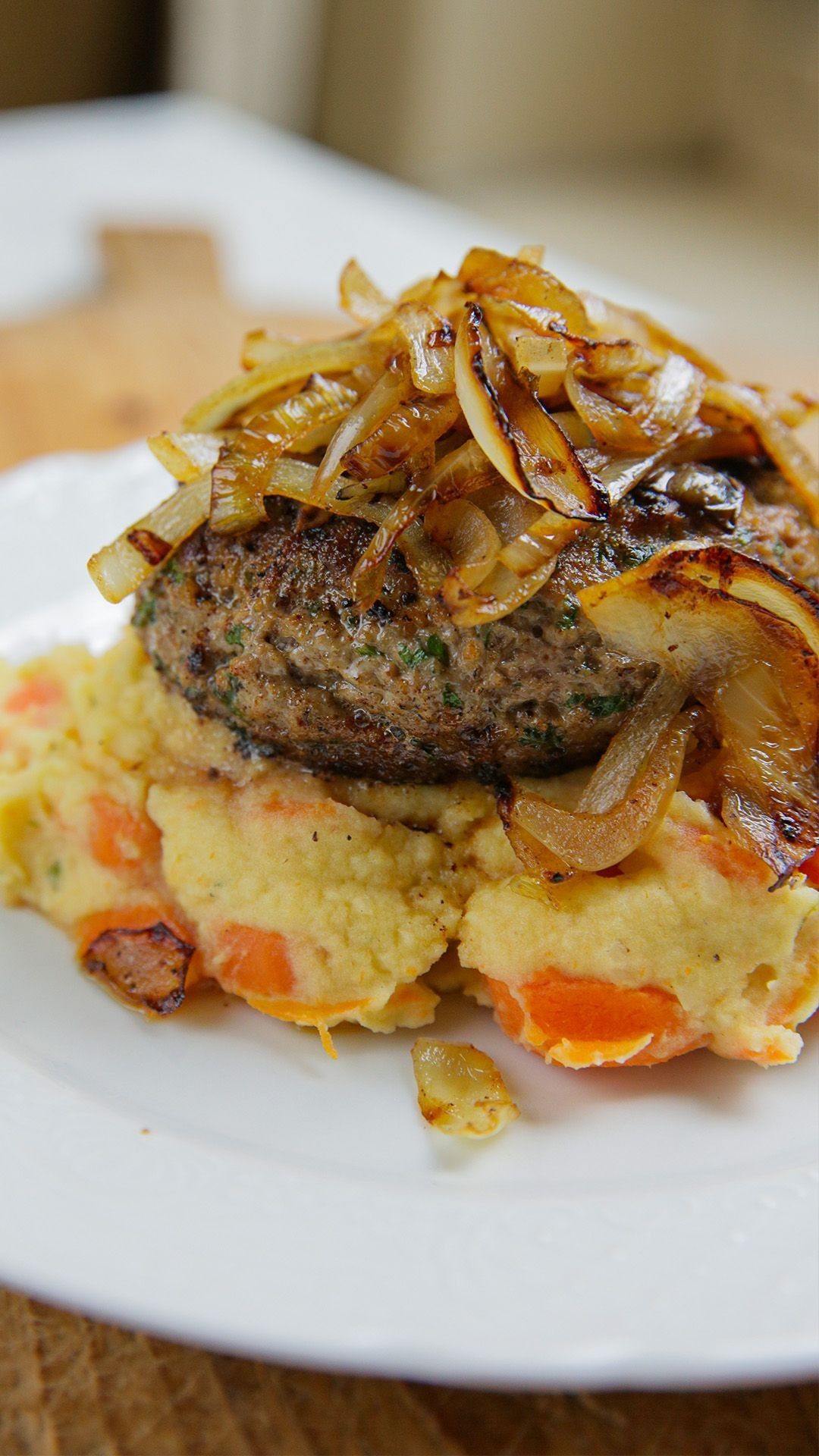 Hamburger met wortelpuree en gebakken ui