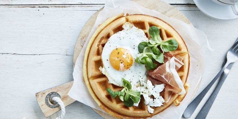 Ontbijtwafel met spiegeleitje, gedroogde ham en geitenkaas