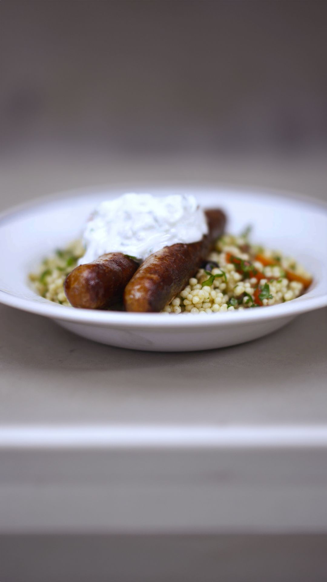 Merguez en lauwe couscoussalade met kerstomaat en tzatziki