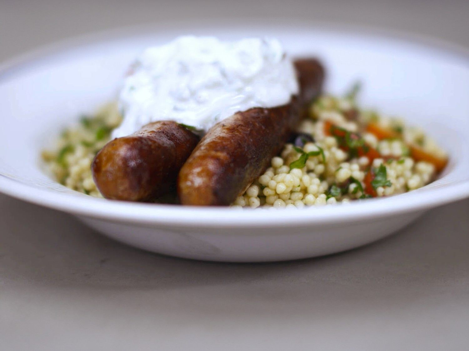 Merguez en lauwe couscoussalade met kerstomaat en tzatziki