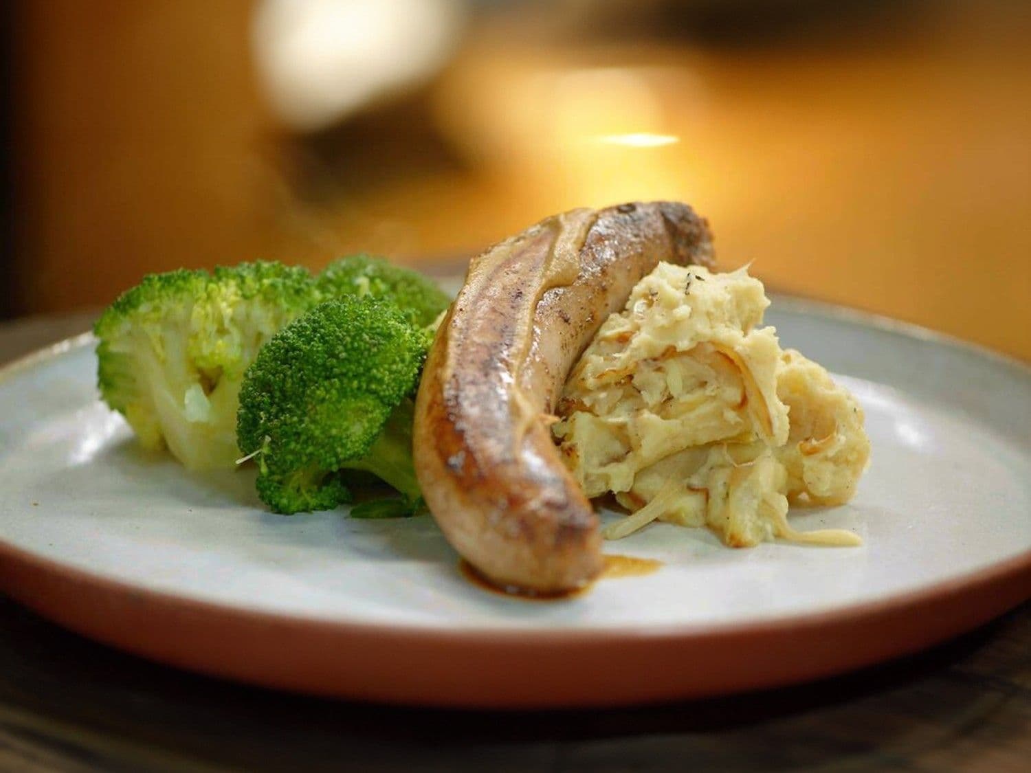 Braadworst met gebakken uienpuree en broccoli