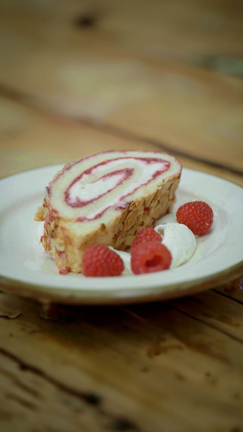 Rolcake met frambozen, witte chocolade en amandelschilfers